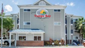 Un hôtel de la chaîne Tampa Bay Extended Stay, reconnaissable à son grand panneau, à son entrée abritée et à sa façade en briques.