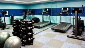 Een sportschool met loopbanden, elliptische trainers en gewichthefapparatuur.