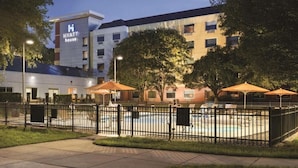 Un hôtel Hyatt doté d’une piscine, entouré d’une clôture et d’arbres.