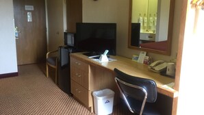 A hotel room with a desk, chair, television, and a trash bin. - Motel 6 Coraopolis, PA Pittsburgh Airport (Coraopolis)