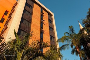 Un immeuble à plusieurs étages, doté d’une façade en briques, de grandes fenêtres et d’une flèche imposante.