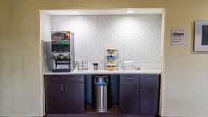 A small kitchenette with a coffee machine, a trash can, and a shelf with condiments. - Quality Inn Whiteville North (Whiteville)