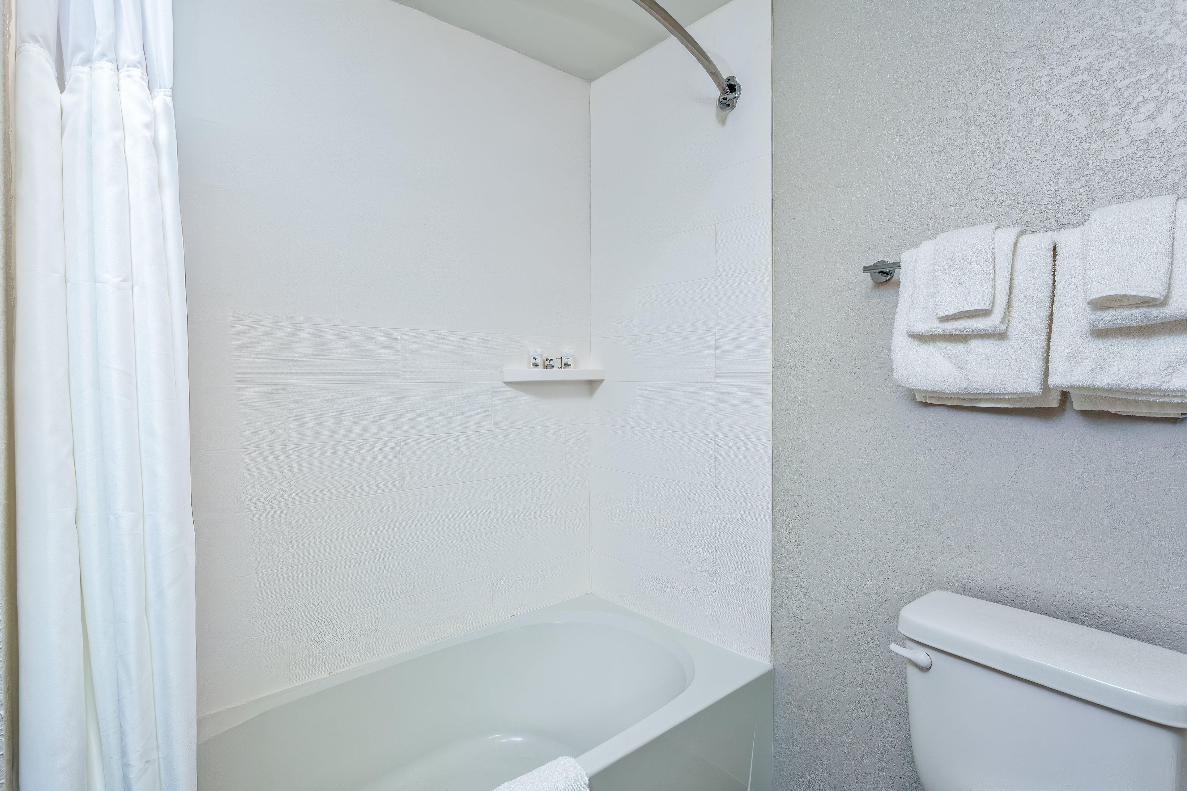 A bathroom with a bathtub, shower, and toilet.