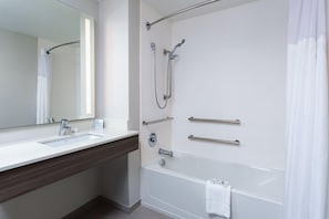 A modern bathroom with a white sink, mirror, and bathtub. - Holiday Inn Express & Suites Palm Coast - I-95 (Palm Coast)