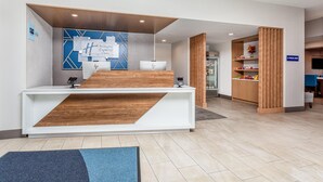 Un mostrador de recepción de diseño moderno, una pared azul con patrones geométricos y un letrero que indica una tienda E-Press.