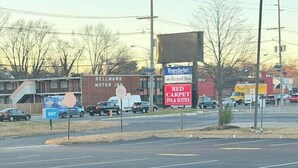 Ein Parkplatz mit einem Red Carpet Inn & Suites Schild, einem Travelodge Schild und einem Royal Inn Schild.
