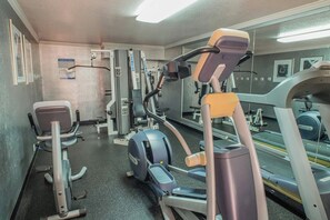 A gym with exercise equipment, a mirrored wall, and a treadmill. - Uptown Oasis San Jose Airport (San Jose)