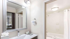 A bathroom with a white sink, mirror, and toilet. - Uptown Oasis San Jose Airport (San Jose)