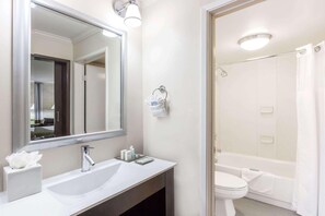 A bathroom with a white sink, mirror, and toilet. - Uptown Oasis San Jose Airport (San Jose)