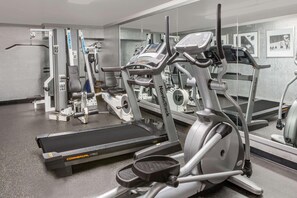 Et fitnesscenter med løbebånd, crosstrainere og styrkemaskiner.