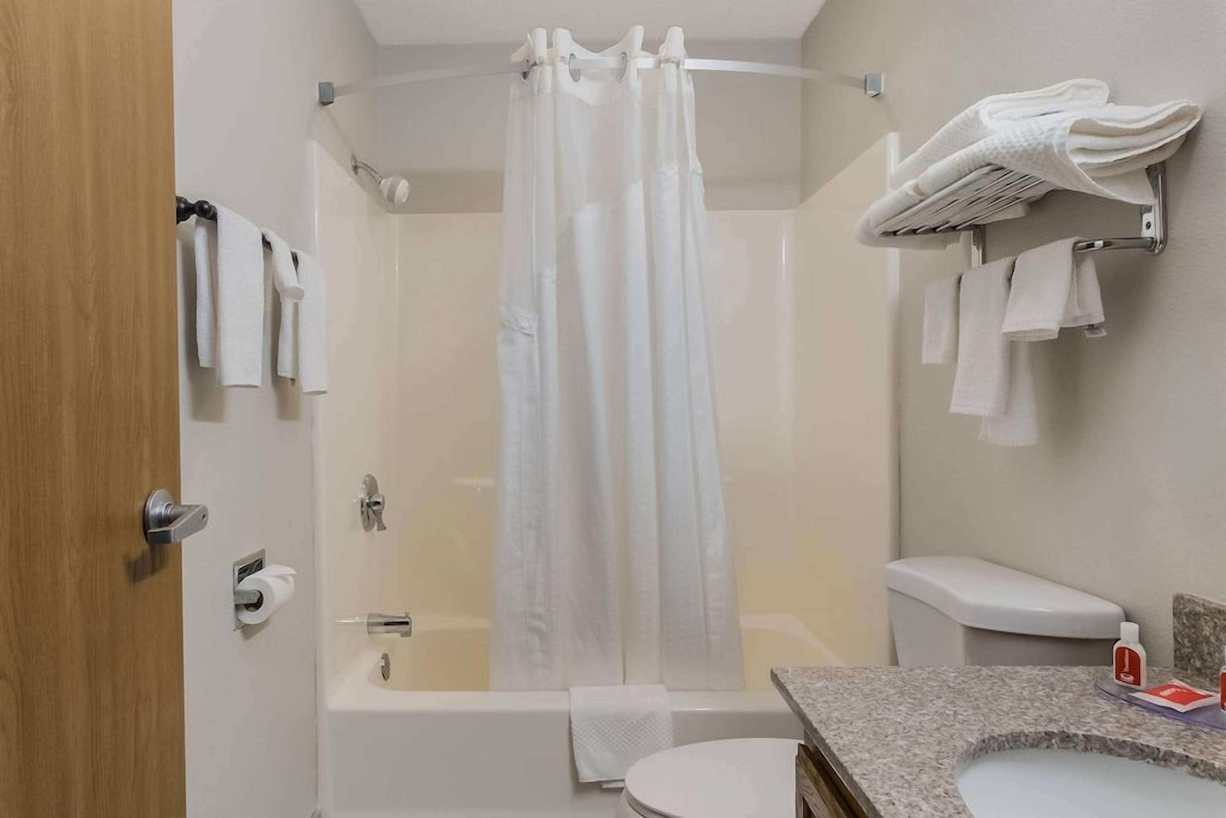 A bathroom with a shower, toilet, and sink.