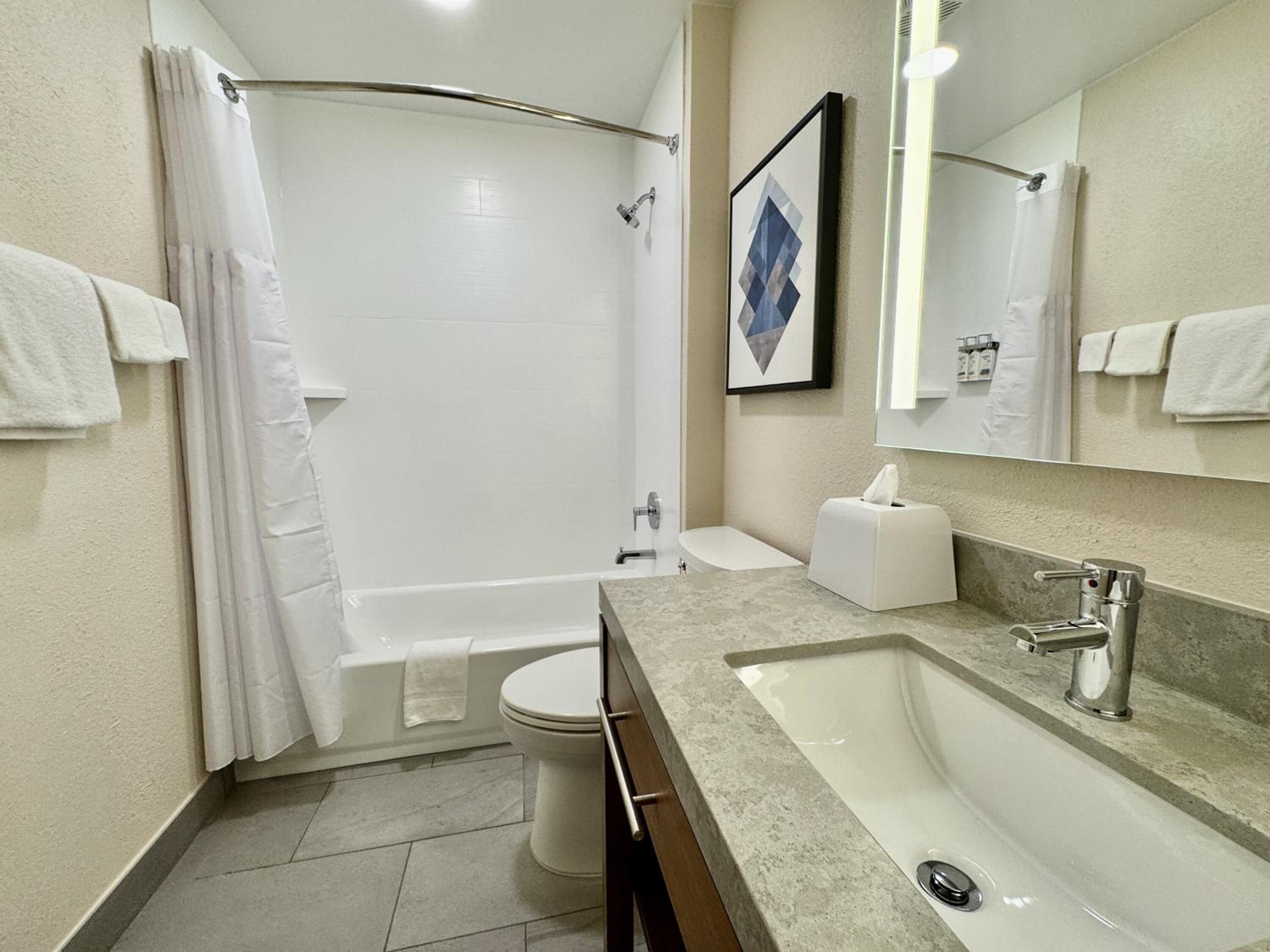 A modern bathroom with a bathtub, toilet, and sink.
