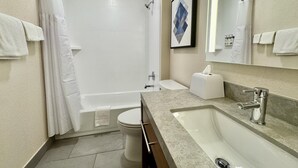 A modern bathroom with a bathtub, toilet, and sink.