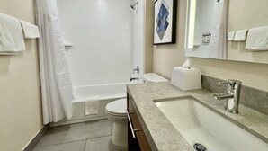 A modern bathroom with a bathtub, toilet, and sink.