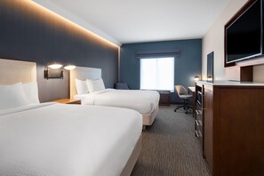 Une chambre d’hôtel avec deux lits, un bureau, une chaise, une télévision et une grande fenêtre.