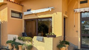 A building with a large window, a door, and potted plants. - Nice apartment in Lopar with WiFi (Lopar)