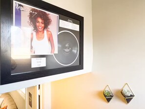 Ein gerahmtes Bild von Whitney Houston an einer Wand, inklusive Veröffentlichungsdatum und Aufnahmedetails.