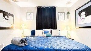 Un dormitorio con una cama grande, dos mesitas de noche y una cortina negra.