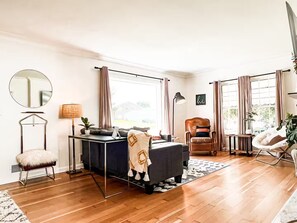 Una sala de estar moderna con un sofá, un sillón y una pequeña mesa con una lámpara.