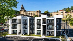 Un parking à étages avec un ciel dégagé et un bâtiment visible au loin.