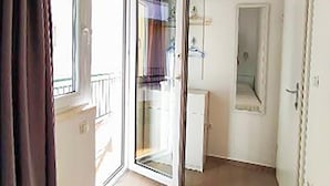 A room with a sliding glass door leading to a balcony, a small white cabinet, and a mirror on the wall. - Gorgeous apartment in Podgora with WiFi (Podgora)