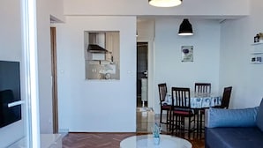 A modern living room with a sofa, a dining table with chairs, a kitchen area, and a ceiling light fixture. - Gorgeous apartment in Podgora with WiFi (Podgora)