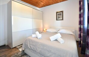 A hotel room with a bed, a wardrobe, a nightstand, and a framed picture on the wall. - Amazing home in Donji Bitelic (Donji Bitelic)