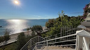 Udsigt over kysten med en trappe, der fører til en balkon med havudsigt.