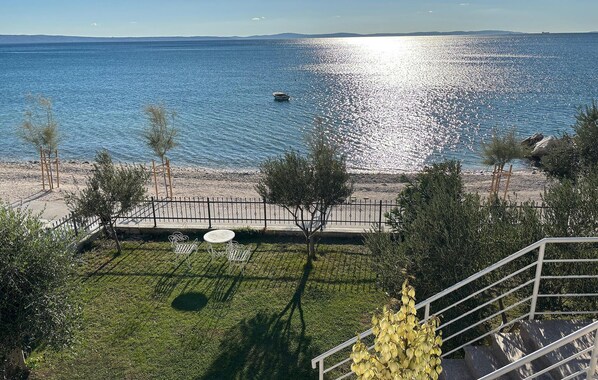 Une vue sur la côte, avec une plage, un petit bateau et un ciel dégagé.