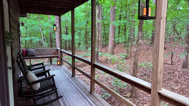 A wooden deck with a bench and a lantern, overlooking a forest. - Blue Spirit · Private Studio Cabin in the Trees (Caddo Gap)