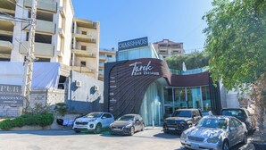 A building with a large sign for 'Tarek Hair Designer' and 'Glasshaus' on the facade. - GlassHaus Rooftop 2-BR & Pool in Ghazir (Ghazir)