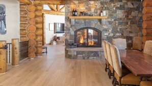 A rustic interior with a stone fireplace, wooden beams, and a dining area. - The Wilson Vista: Epic Space & Solitude (Mountain Village)