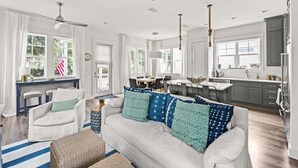 Ein geräumiges Wohnzimmer mit einer Couch, einem Essbereich und einer Küche.