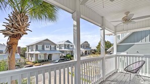 A covered porch with a white railing, a palm tree, and a chair. - Private Pool, LSV/Golf Cart, Bikes, & Pet Friendly! 1/2 MILE TO BLUE MOUNTAIN BEACH! (Santa Rosa Beach)