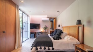 Un dormitorio moderno con una cama grande, un escritorio y una televisión.