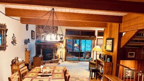 Ein gemütliches Wohnzimmer mit Kamin, Holzmöbeln und Blick ins Freie.