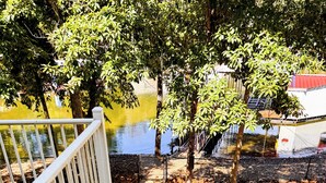 A wooden staircase with white railings leading to a pathway beside a body of water. - Lakefront Retreat - Mile Marker 42 - Dock Bar + Sleeps 15! (Roach)