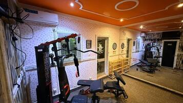 Academia com equipamentos de ginástica, espelho e parede estampada.