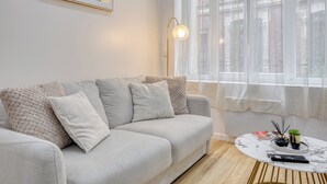 Un salon moderne avec un canapé gris, une table basse ronde et un lampadaire.