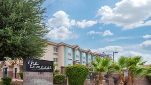 A hotel entrance with a sign, a paved driveway, and a building with multiple windows and balconies. - La Quinta Inn & Suites Tempe University / Phoenix (Tempe)