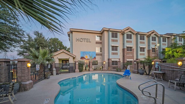 A hotel with a swimming pool, outdoor seating, and a mural on the building. - La Quinta Inn & Suites Tempe University / Phoenix (Tempe)