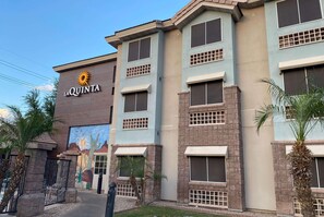 A multi-story hotel with a prominent 'LA QUINTA' sign, large windows, and a mural on the side. - La Quinta Inn & Suites Tempe University / Phoenix (Tempe)