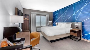 A hotel room with a bed, desk, chair, and a large window. - Comfort Inn & Suites Schulenburg TX (Schulenburg)
