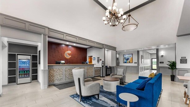 A modern hotel lobby with a reception desk, seating area, and a vending machine. - Comfort Inn & Suites Schulenburg TX (Schulenburg)