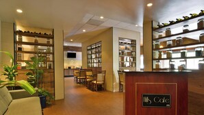 A reception area with a wooden counter, seating, and shelves with jars. - The Hills Hotel (Laguna Hills)