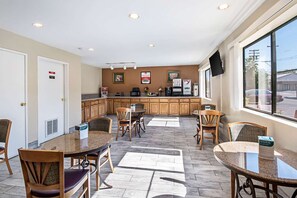 Een hotelkamer met een eethoek, kitchenette en een groot raam met uitzicht.
