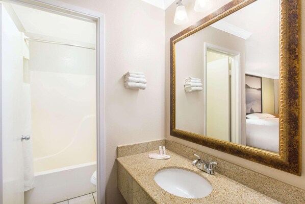 A bathroom with a sink, mirror, and towels. - Upper Lake Inn & Suites (Upper Lake)
