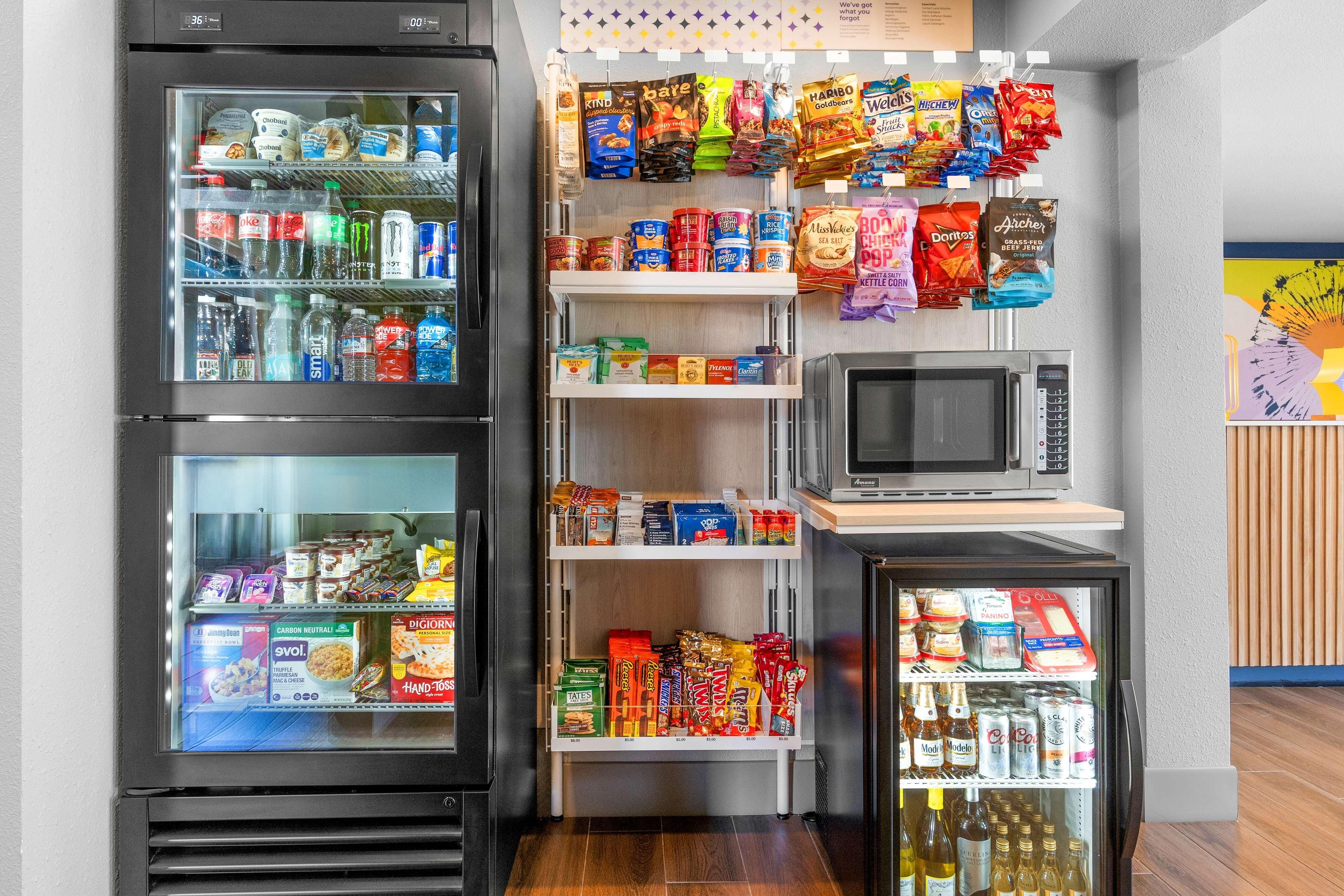 A vending machine area with snacks, drinks, and a microwave.