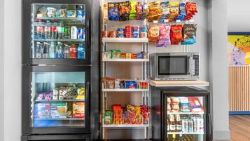 A vending machine area with snacks, drinks, and a microwave.