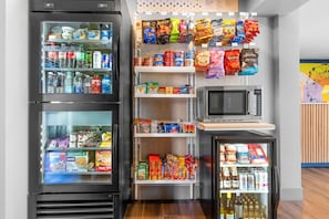 Un espace équipé d’un distributeur automatique proposant des collations, des boissons et un four à micro-ondes.